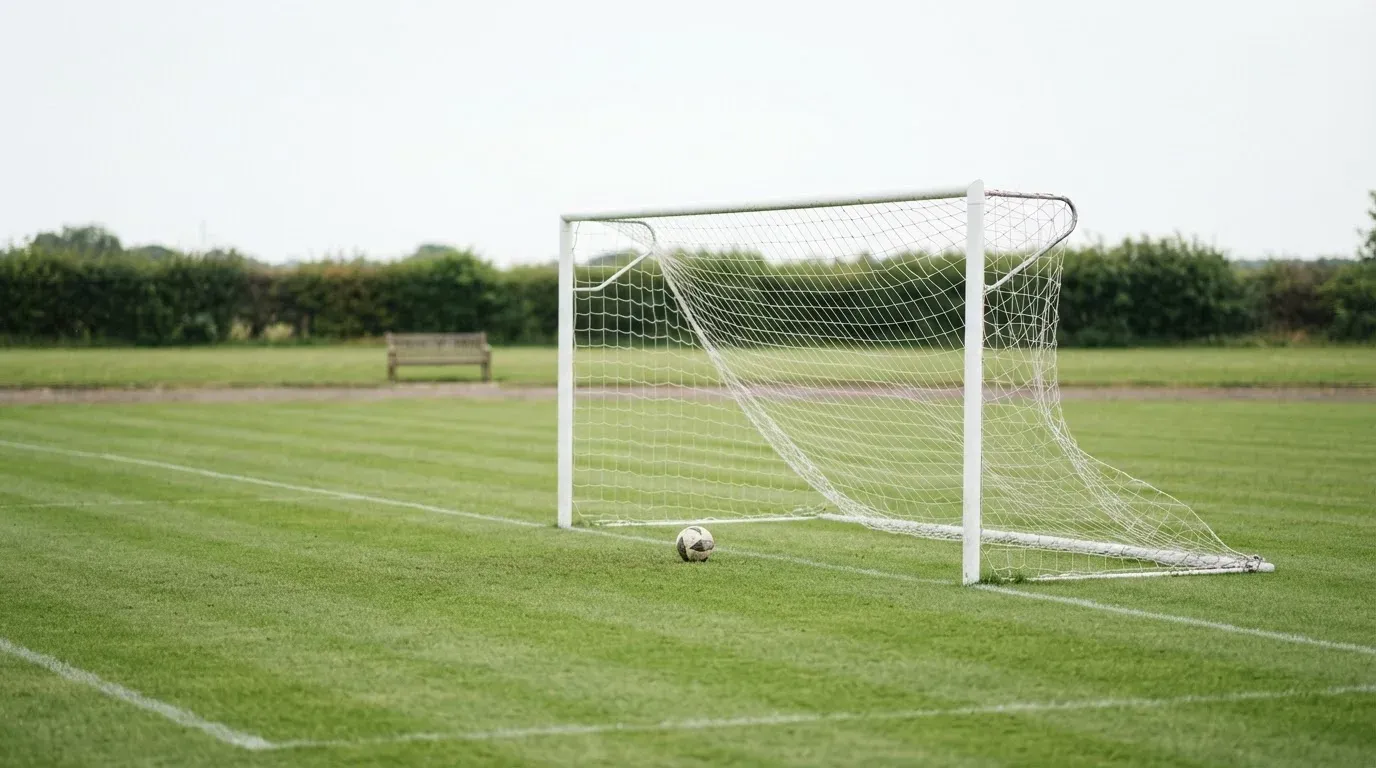 Ein Fussballtor mit locker hängendem Netz auf einem Trainingsplatz, das sich leicht im Wind bewegt.